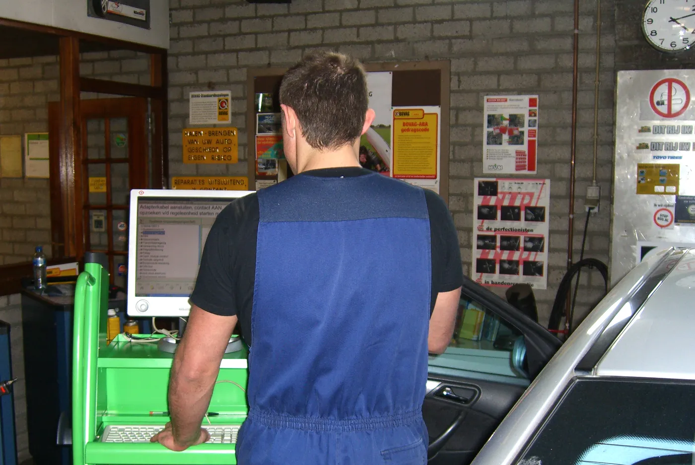 Monteur achter de uitleesapparatuur in de werkplaats